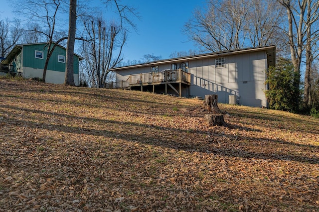 back of property with crawl space and a wooden deck