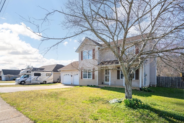 traditional-style home featuring an attached garage, concrete driveway, a front yard, and fence