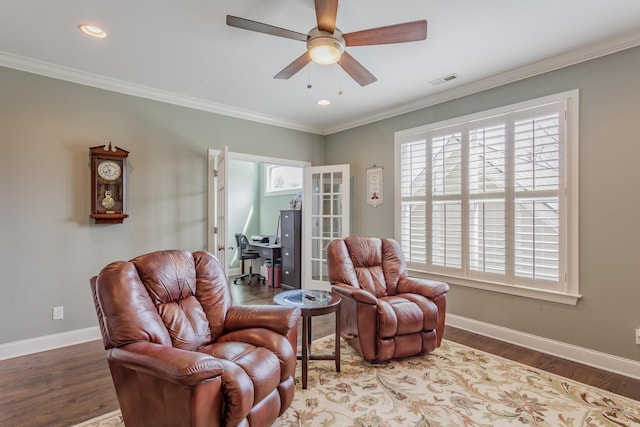 living area featuring visible vents, baseboards, and wood finished floors