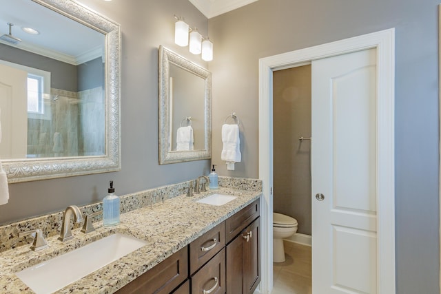 bathroom with tiled shower, toilet, crown molding, and a sink