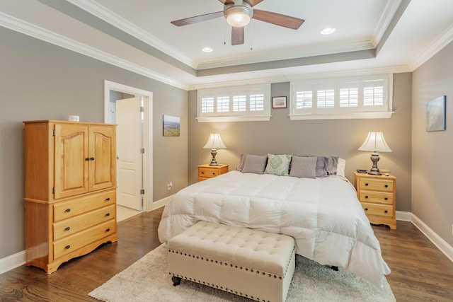 bedroom with a raised ceiling, multiple windows, and dark wood-type flooring