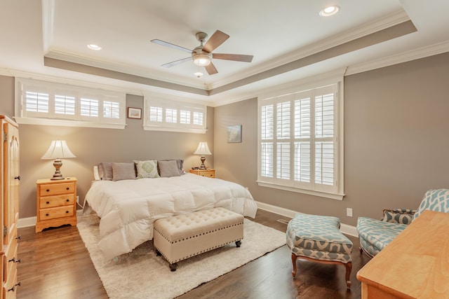 bedroom featuring crown molding, baseboards, a tray ceiling, recessed lighting, and wood finished floors