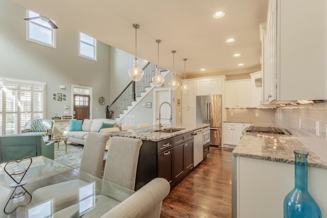 kitchen featuring a wealth of natural light, appliances with stainless steel finishes, dark wood-type flooring, and a sink