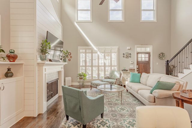 living area featuring a wealth of natural light, stairs, and wood finished floors