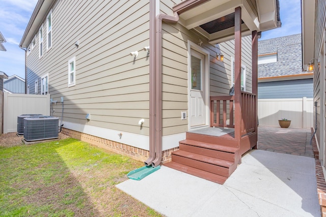 view of home's exterior featuring a yard, central AC unit, and fence