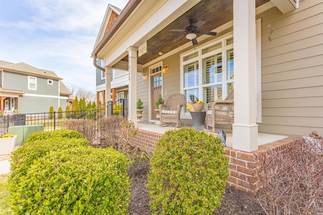 property entrance featuring fence, covered porch, a residential view, and ceiling fan