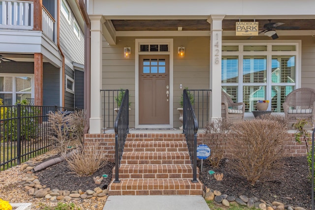 doorway to property featuring a porch and fence