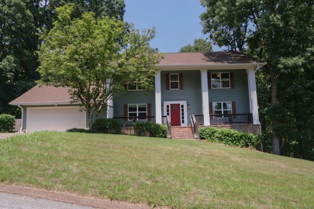 greek revival inspired property with a garage, a porch, and a front lawn