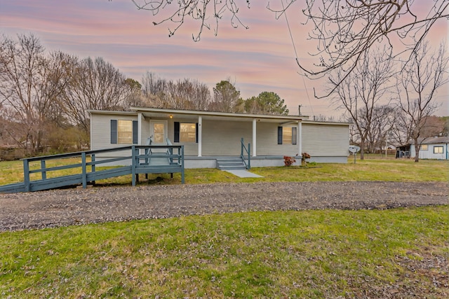 manufactured / mobile home featuring covered porch and a front yard