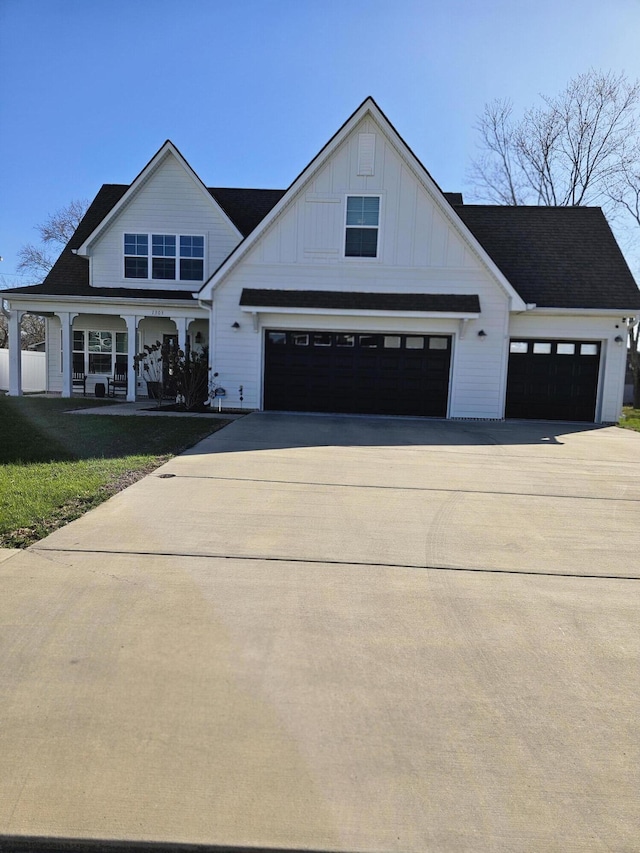 modern inspired farmhouse with board and batten siding, concrete driveway, and a front lawn