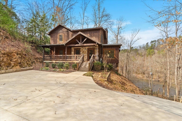 view of front of property with stone siding and covered porch