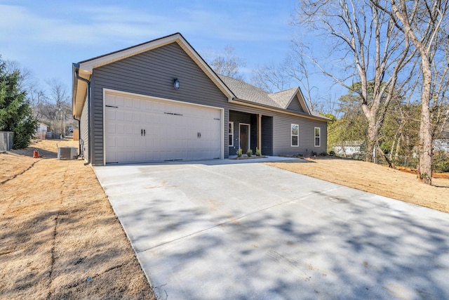 ranch-style home with cooling unit, concrete driveway, and an attached garage