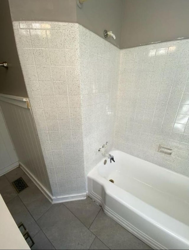 bathroom with washtub / shower combination and tile patterned flooring