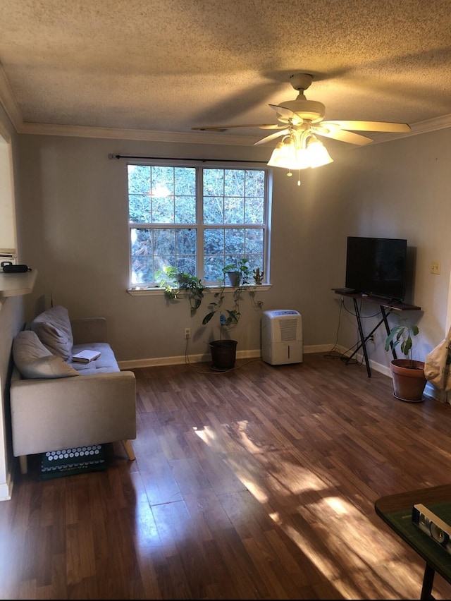 living area with baseboards, a textured ceiling, dark wood finished floors, and crown molding