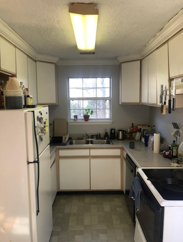 kitchen featuring a sink, black dishwasher, crown molding, and freestanding refrigerator