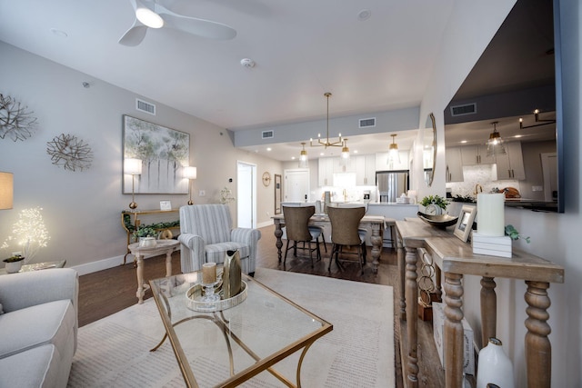 living room with dark wood finished floors, a ceiling fan, visible vents, and baseboards