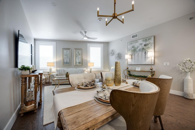 dining room with visible vents, ceiling fan with notable chandelier, baseboards, and wood finished floors