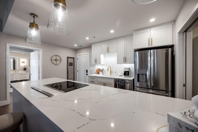 kitchen with a sink, white cabinets, backsplash, and stainless steel appliances