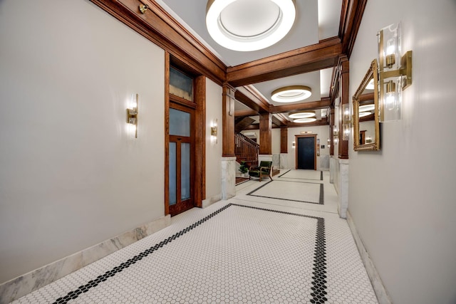 corridor featuring beamed ceiling, baseboards, coffered ceiling, and crown molding