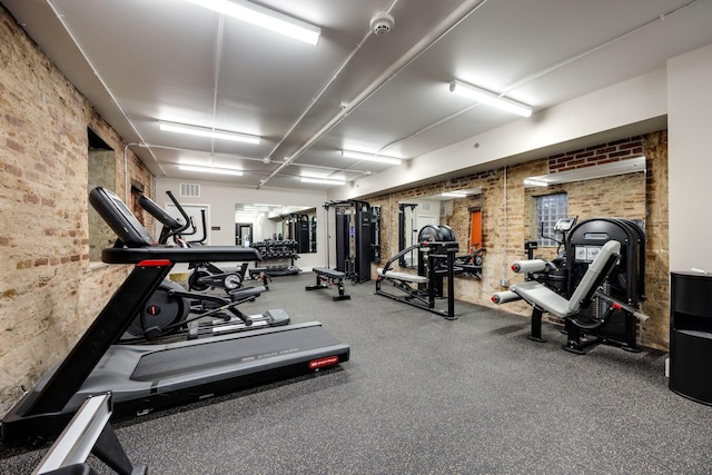 gym with visible vents and brick wall