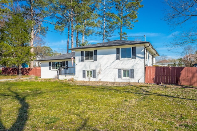 back of house featuring a lawn and fence