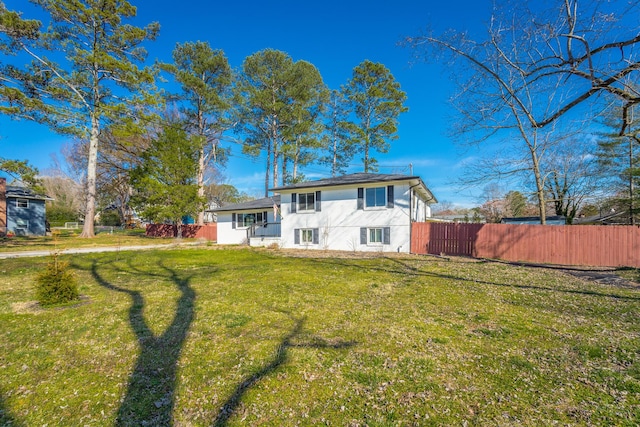 back of property featuring a yard and fence