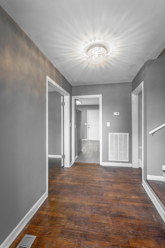 hallway featuring baseboards, visible vents, and wood-type flooring