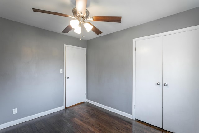 unfurnished bedroom with a closet, a ceiling fan, baseboards, and dark wood-style flooring