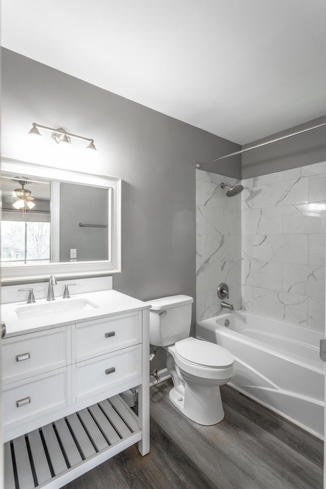 bathroom featuring toilet, washtub / shower combination, vanity, and wood finished floors