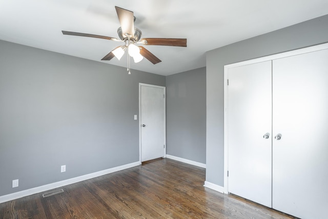 unfurnished bedroom featuring visible vents, baseboards, wood finished floors, a closet, and a ceiling fan