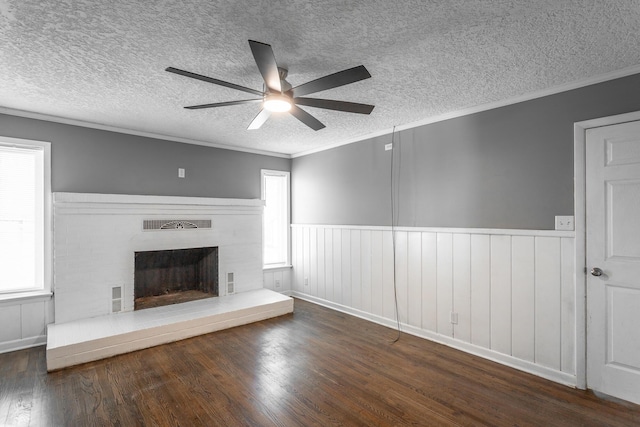 unfurnished living room featuring a fireplace with raised hearth, wood finished floors, and ornamental molding