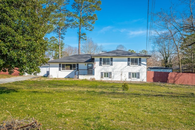 tri-level home featuring a chimney, a front yard, and fence