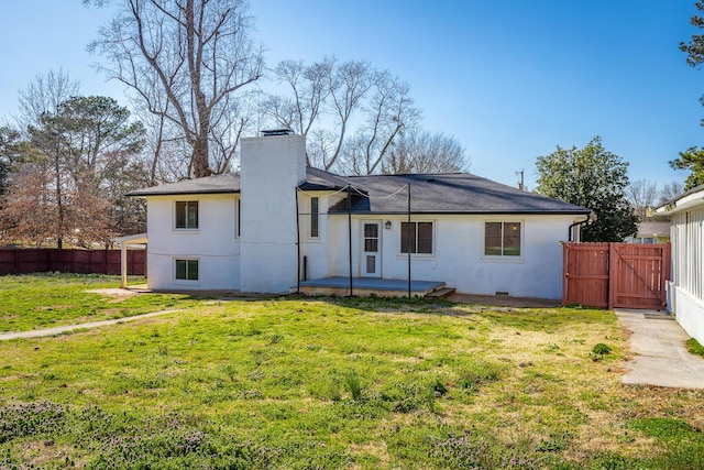 rear view of property with a patio, fence, a lawn, and brick siding