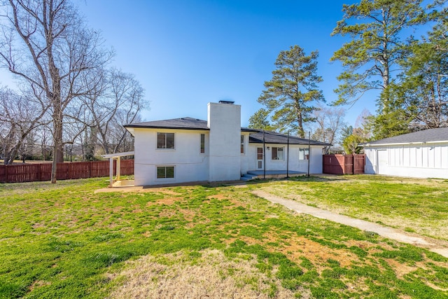 rear view of house featuring a patio area, a lawn, a chimney, and a fenced backyard