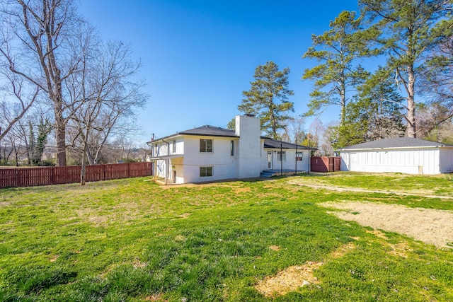 back of property with fence private yard, a chimney, and a yard