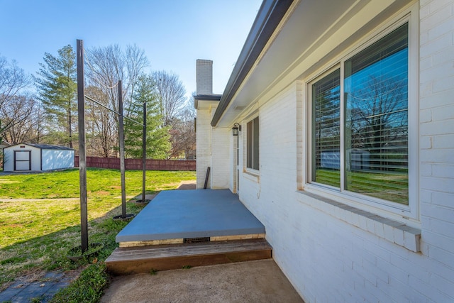 exterior space with a storage unit, an outdoor structure, and fence