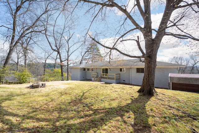 back of property with a lawn and fence