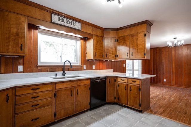 kitchen with light countertops, black dishwasher, brown cabinets, and a sink