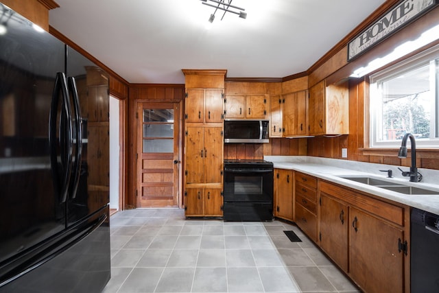 kitchen with light countertops, light tile patterned floors, brown cabinets, black appliances, and a sink