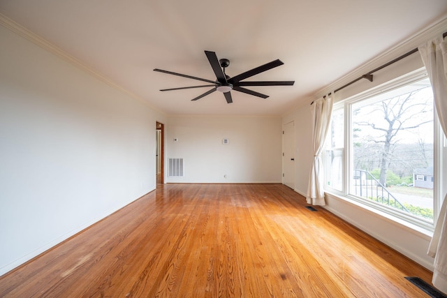 unfurnished room with light wood-style floors, a ceiling fan, visible vents, and ornamental molding