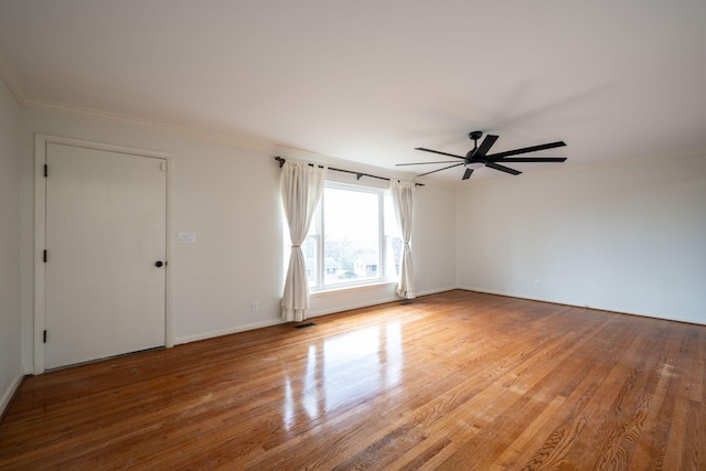 spare room featuring visible vents, wood finished floors, a ceiling fan, and ornamental molding