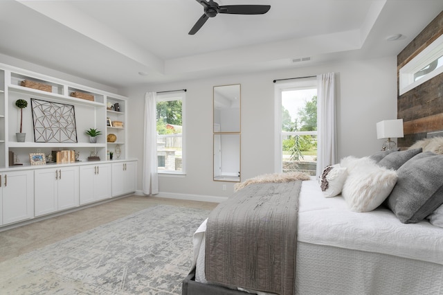 bedroom featuring visible vents, ceiling fan, a raised ceiling, and baseboards