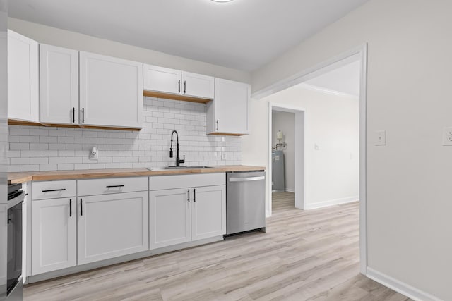 kitchen with dishwasher, stove, a sink, and butcher block countertops