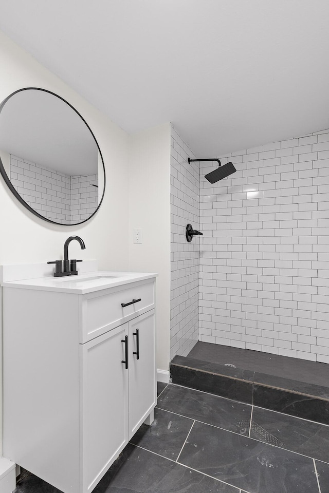 bathroom featuring tiled shower and vanity