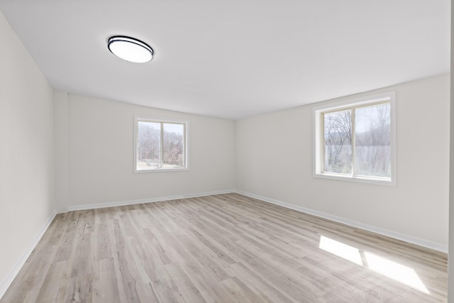 empty room featuring baseboards and light wood-type flooring