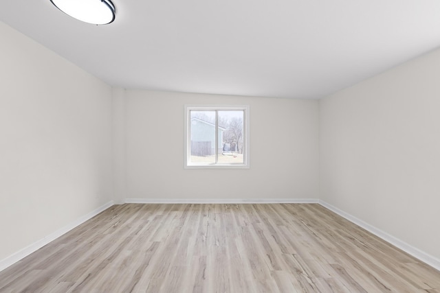 spare room featuring baseboards and wood finished floors