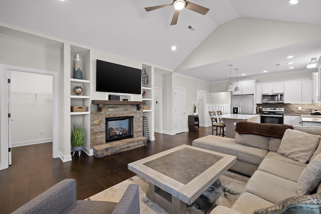 living room featuring a ceiling fan, baseboards, dark wood finished floors, recessed lighting, and a stone fireplace