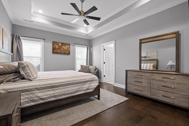 bedroom featuring baseboards, visible vents, ornamental molding, dark wood-type flooring, and a raised ceiling