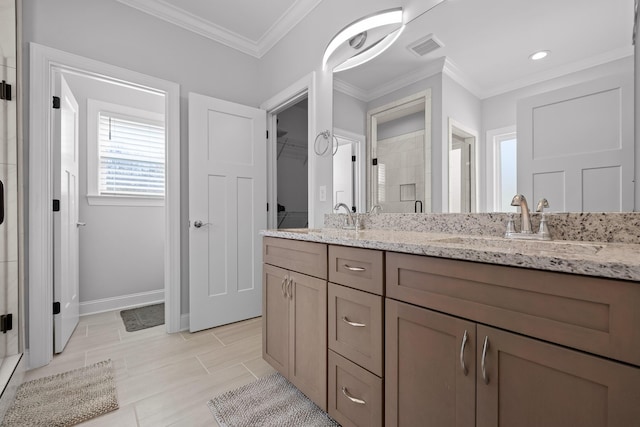 bathroom with visible vents, a shower stall, double vanity, ornamental molding, and a sink