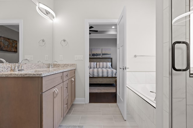 full bath featuring double vanity, a sink, tiled bath, tile patterned floors, and connected bathroom